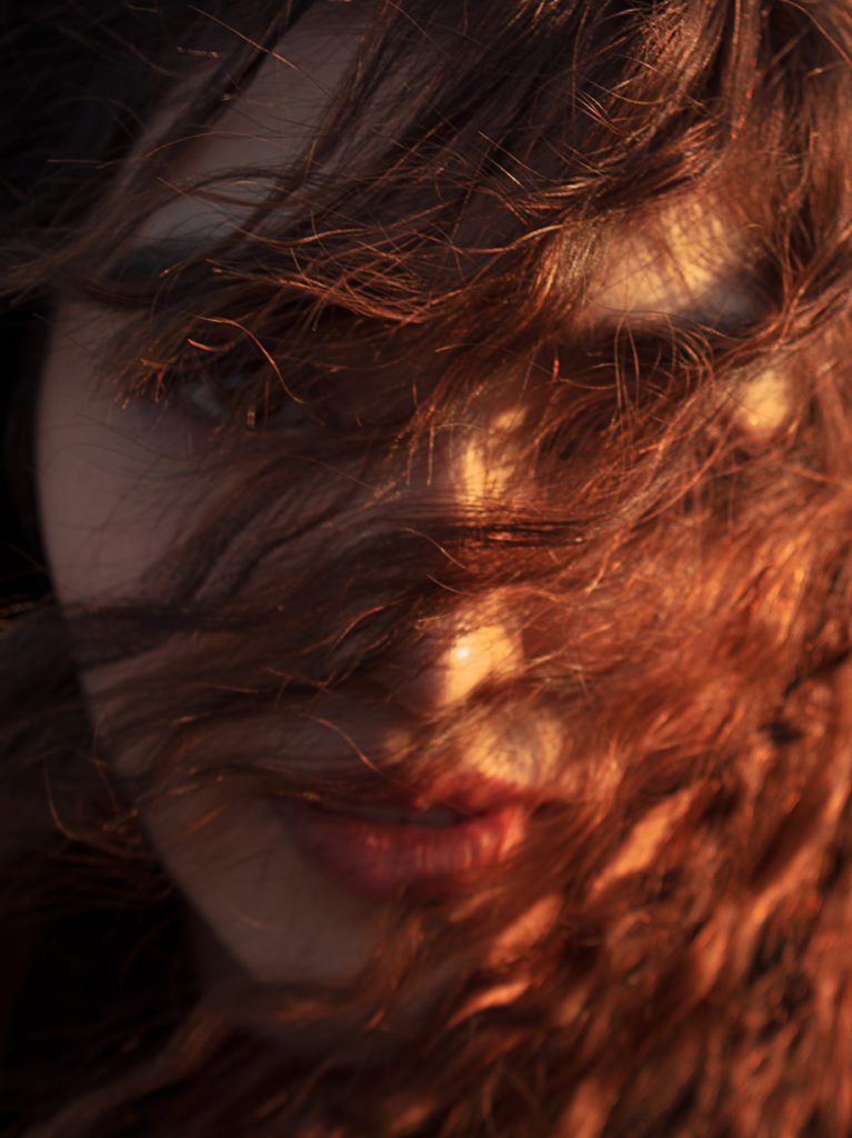 Frisur-Trend 2023 Kupfer: Eine Frau mit kupfernen Haaren vor dem Gesicht.