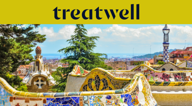 Ein malerischer Blick auf Barcelona vom Park G&uuml;ell aus, mit Antoni Gaud&iacute;s ber&uuml;hmten bunten Mosaikb&auml;nken und m&auml;rchenhaften T&uuml;rmen im Vordergrund, dahinter die Stadt und das Meer. Ein gelbes Banner am oberen Rand zeigt das &bdquo;treatwell&ldquo;-Logo.
