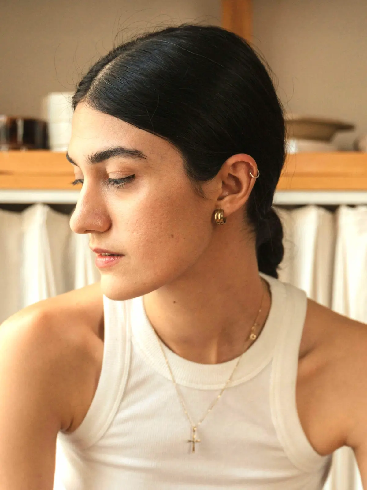 Frau sitzt auf einem Hocker und trägt einen Ring in ihrem Helix-Piercing