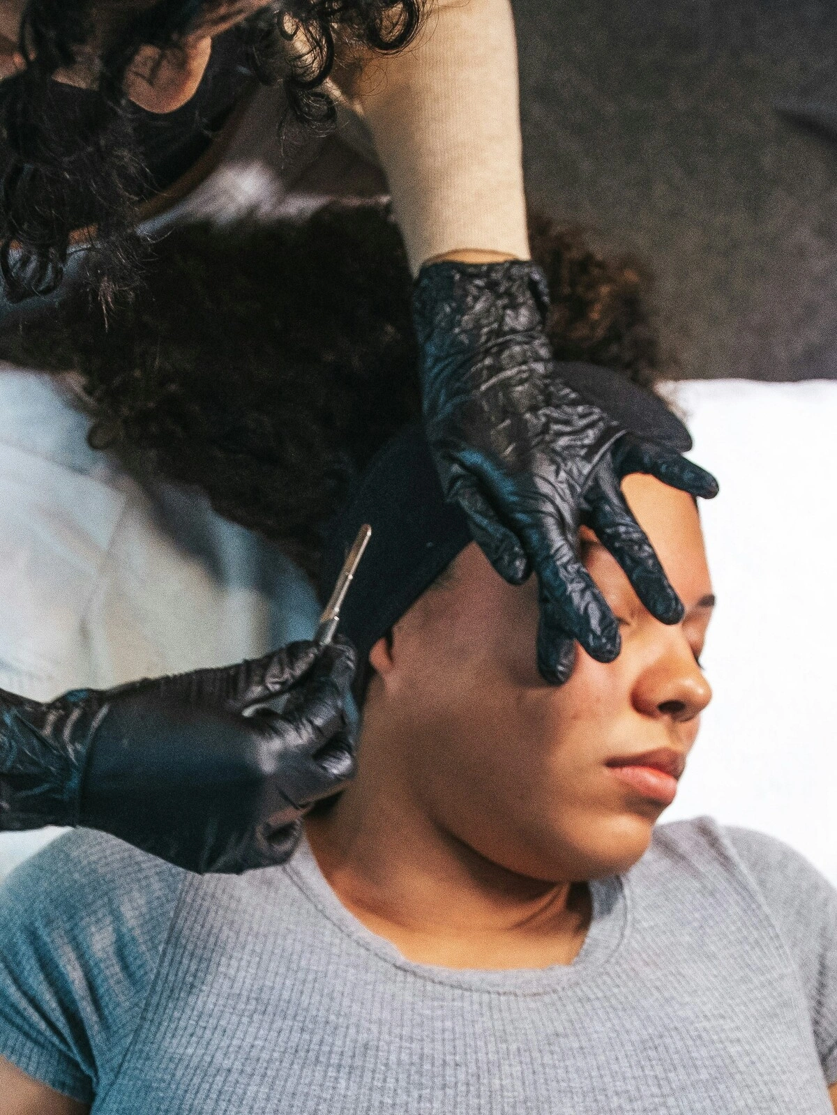 Draufsicht auf eine Kosmetikerin, die bei einer Kundin im Salon ein Dermaplaning durchführt