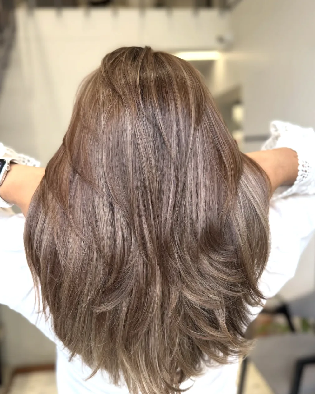 Lange, gestufte Haare in einem mehrtönigen Taupe-Truffle-Brünett